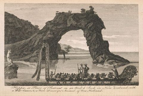 Print. A long, highly decorated canoe rowed by eighteen men glides in front of a natural stone arch. A kangaroo looks on from a rock to our left. Text beneath the image reads, \“Hippa, or Place of Retreat on an Arch’d Rock in New Zealand, with a War canoe: & a Non Descript Animal of New Holland\”.